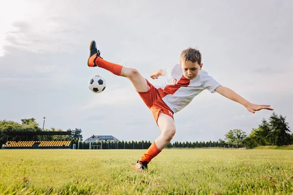 8 jaar oude jongenskind spelen voetbal en rollen over — Stockfoto