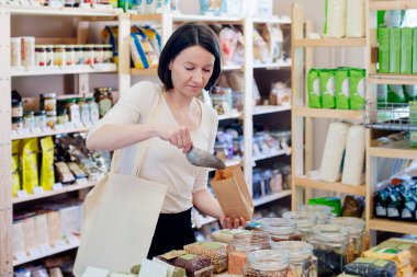 Kadın mercimek tohum bir kağıt torbaya koyar.
