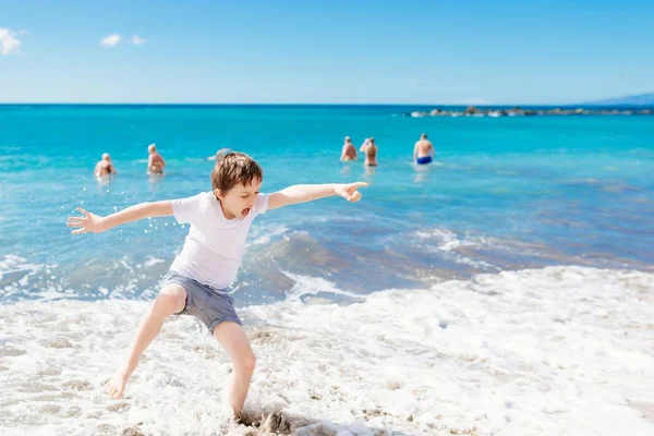 Feliz niño saltando y jugando en la playa — Foto de Stock
