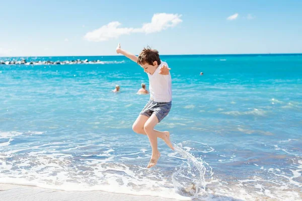 Joyeux enfant sautant et jouant sur la plage — Photo