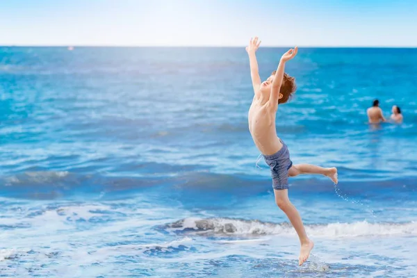 Joyeux enfant sautant et jouant sur la plage — Photo