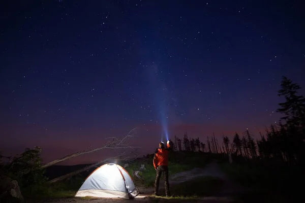 Uomo turista che punta la sua torcia al cielo stellato — Foto Stock
