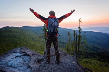 Adam turist gündoğumu kayaya üstündeki.