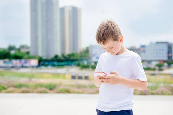 Chłopiec dziecko grając gier mobilnych na swoim smartfonie — Zdjęcie stockowe