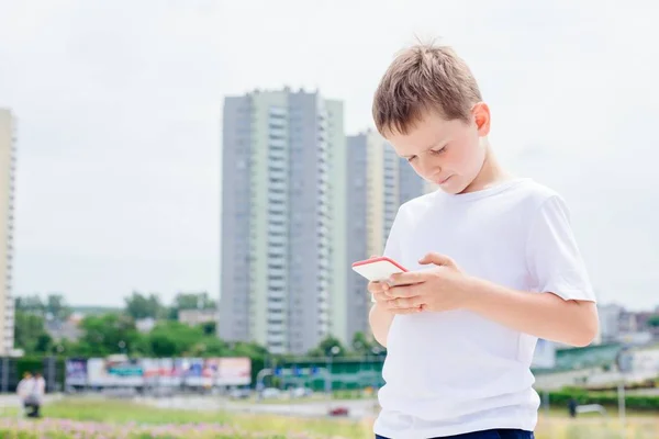 Dítě chlapec hraní mobilních her na jeho smartphone — Stock fotografie