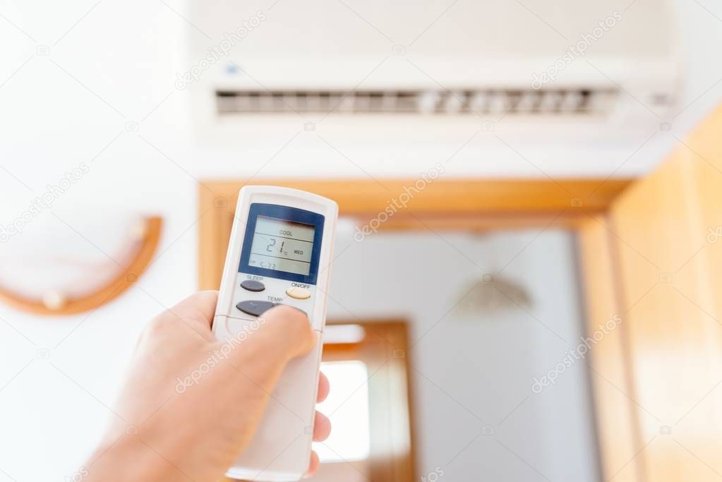 Close up on male hand adjusting home air condition