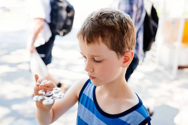 Mały chłopiec dziecko bawi się fidget spinner — Zdjęcie stockowe