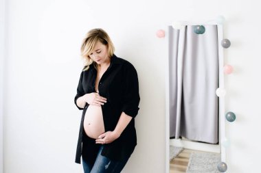 Güzel genç hamile ayakta yatak odasında