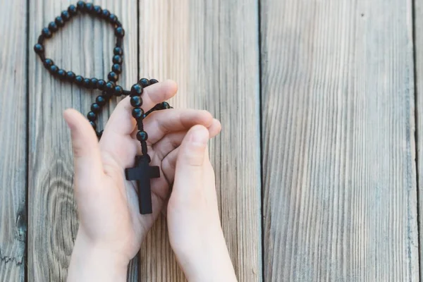 Piccoli bambini mani tenendo rosario in legno — Foto Stock