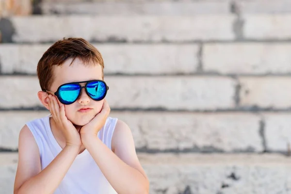 Bambino bambino che indossa occhiali da sole e seduto su vecchie scale — Foto Stock