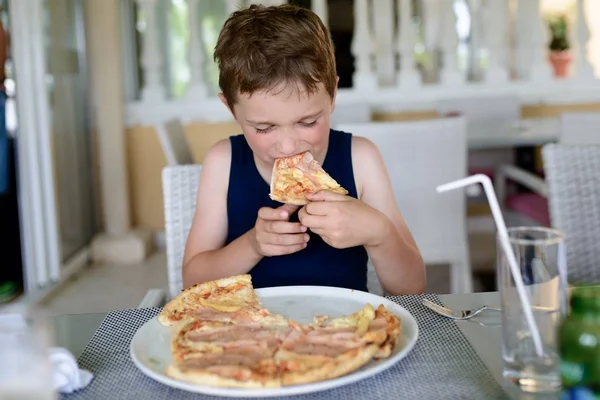 Pojken äta läckra pizza. — Stockfoto