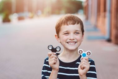 Açık havada topluca spinner ile oynarken küçük çocuk çocuk