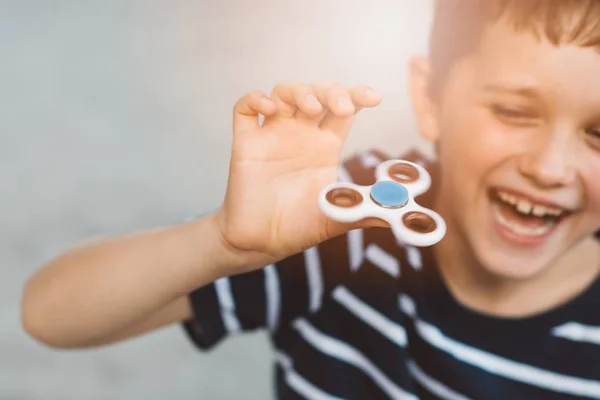 Niño pequeño jugando con fidget spinner al aire libre — Foto de Stock