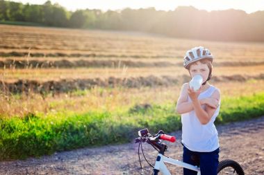 Çocuk Bisiklet kask içinde şişe suyu içer