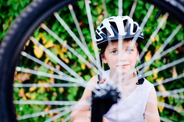 Szczęśliwy chłopiec w kask rowerowy, naprawy swojego roweru — Zdjęcie stockowe