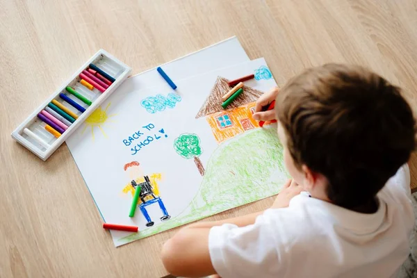 Kind zeichnet Bild eines Jungen, der zur Schule geht. — Stockfoto