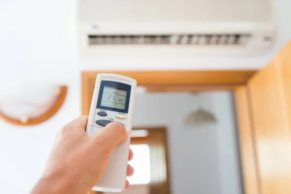 Hand aan te passen temperatuur van home air conditioner — Stockfoto