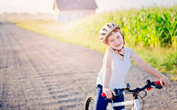 Çocuk çocuk üzerinde bisiklet sürme Beyaz Bisiklet kask içinde