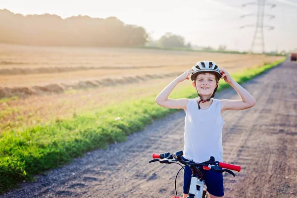 Niño niño en casco de bicicleta blanco montar en bicicleta —  Fotos de Stock