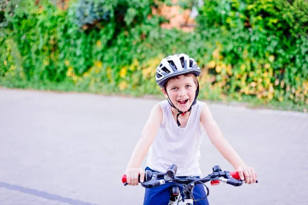 Хлопчик дитина в білому шоломі їде на велосипеді — стокове фото