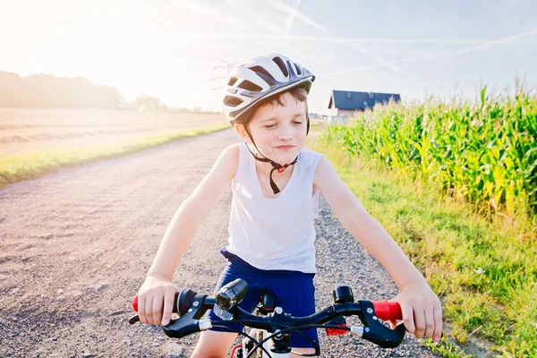 Boy child in white bicycle helmet riding on bicycle — Stock Photo, Image