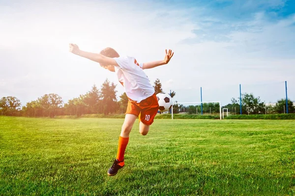 Мальчик играет в футбол на игровом поле . — стоковое фото