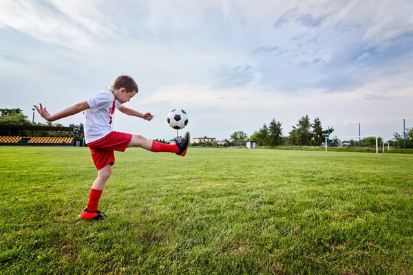 Chłopiec gry z piłki nożnej na boisku. — Zdjęcie stockowe