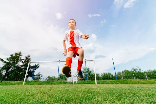 Niño jugando con pelota de fútbol en el campo de juego . —  Fotos de Stock