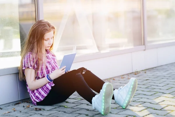 Skolflicka studerar utomhus nära skolan — Stockfoto