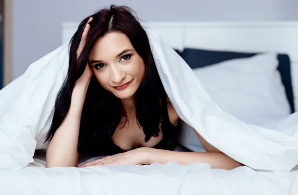 Красивая юная брюнетка женщина расслабляется и отдыхает в постели — стоковое фото