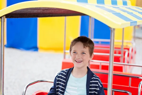 Menino feliz se divertindo no parque de diversões . — Fotografia de Stock