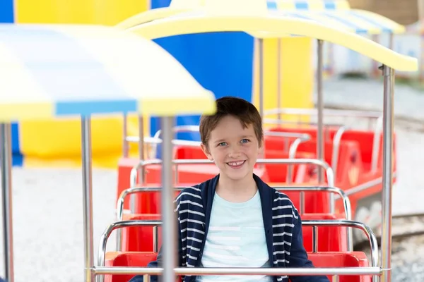 Lyckligt barn pojke ha roligt i nöjesparken. — Stockfoto