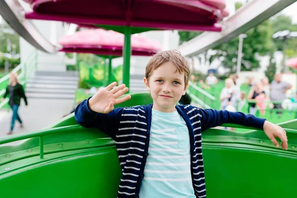 Menino feliz se divertindo no parque de diversões . — Fotografia de Stock