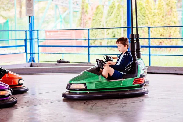 Menino feliz se divertindo no parque de diversões . — Fotografia de Stock