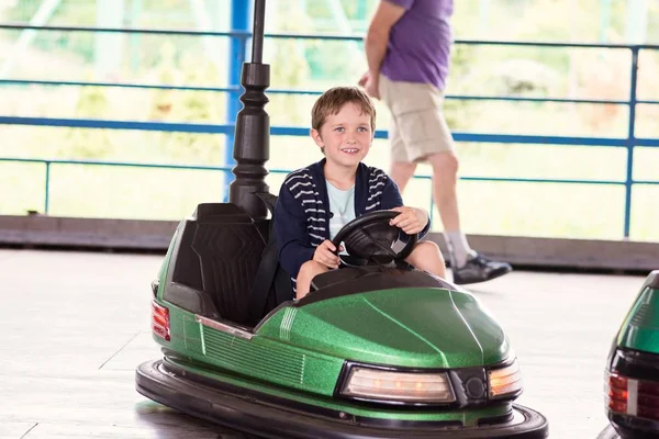 Menino feliz se divertindo no parque de diversões — Fotografia de Stock