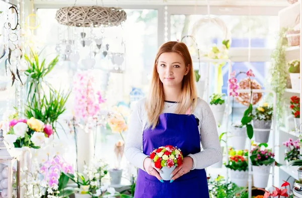 Young woman owner of florist shop holding a composition on beauty flower — Stock Photo, Image