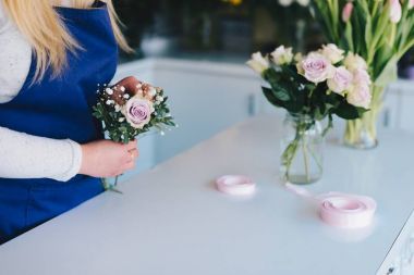 Kadın pembe gül buketi hazırlanıyor çiçekçi dükkanı sahibi