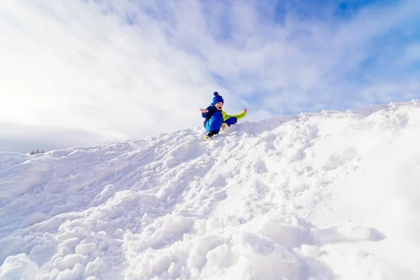 Ребенок веселится на снежном холме . — стоковое фото