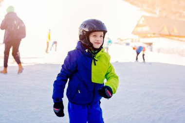 Sekiz yaşında çocuk kayak pisti üzerinde kask içinde.