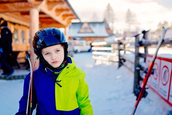 Восьмирічний хлопчик у шоломі на лижному схилі . — стокове фото