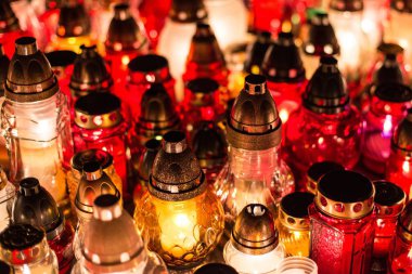 Geceleri mezarlığı üzerinde renkli mumlar yanan.