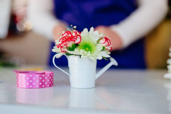 Florista mujer haciendo una composición de flores en miniatura — Foto de Stock