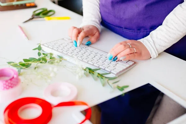 コンピューターのキーボードで入力する花屋の女性オーナー. — ストック写真