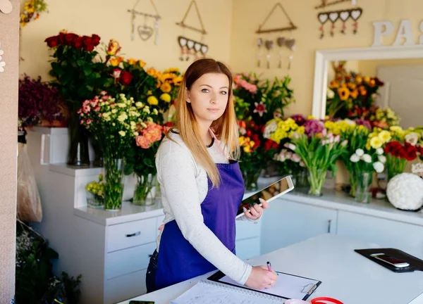 Woman owner of florist shop taking orders online