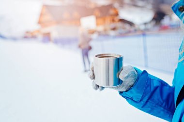 Sıcak çay ile paslanmaz Kupası tutan kadın