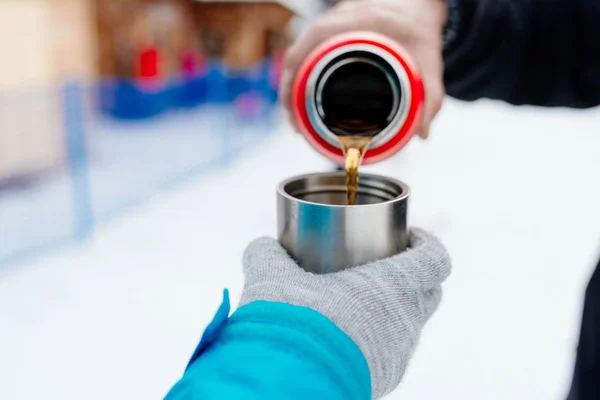 Woman pours hot tea or coffee from metal thermos — Stock Photo, Image