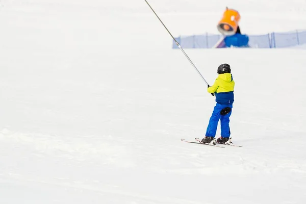 Petit enfant remontant la piste de ski en remontée mécanique . — Photo