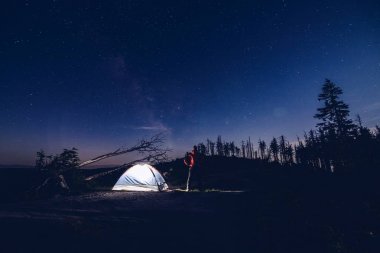 Adam turist dağlarda gece kampta.