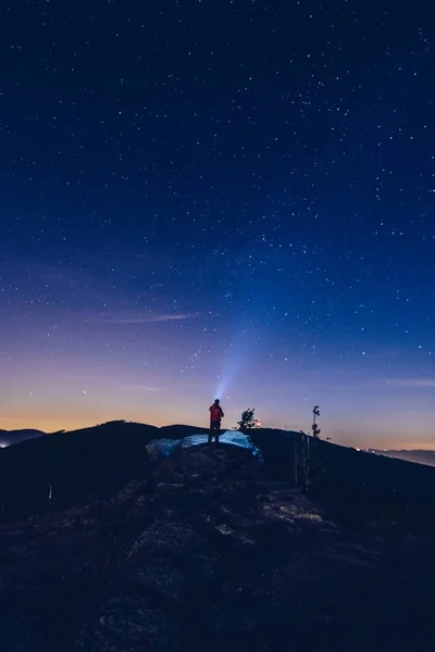 L'uomo punta la luce dalla sua torcia al cielo . — Foto Stock