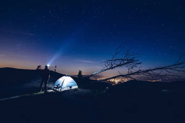 Mann zeigt Licht von seiner Taschenlampe in den Himmel. — Stockfoto